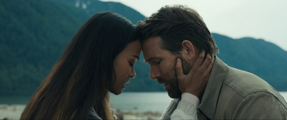 img src="The_Adam_Project_00_47_45_02r.jpg" alt="THE ADAM PROJECT Zoe Saldana as Laura and Ryan Reynolds as Big Adam tender moment by lake"