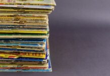 Creating a Clean and Organized Space for Your Comic Books A stack of old comic books with the colors beginning to fade sitting in a pile over a plain gray background.