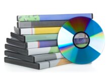 How To Keep Your Unwanted DVDs out of the Trash A small stack of eight plastic DVD cases with different image inserts. A blank disc rests upright against the stack.