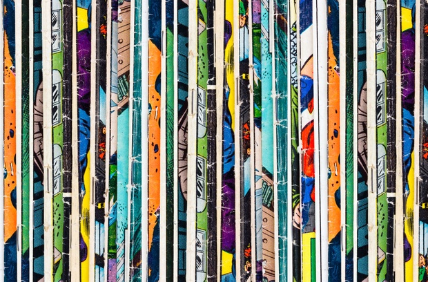 How To Host a Local Comic Book Collectors’ Convention A close-up of various comic books standing upright to see only their spines and small portions of their covers.