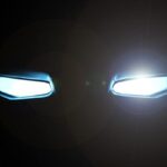 Top 5 Comic-Inspired Cars You Can Actually Drive A black background features two rectangular-shaped eyes glowing with a bright white light and a slight glare.