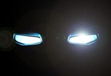 Top 5 Comic-Inspired Cars You Can Actually Drive A black background features two rectangular-shaped eyes glowing with a bright white light and a slight glare.