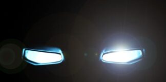 Top 5 Comic-Inspired Cars You Can Actually Drive A black background features two rectangular-shaped eyes glowing with a bright white light and a slight glare.