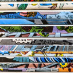 Insurance Tips for Collectors and Hobbyists A close-up of a stack of vintage comic books with colorful, illustrated covers partially visible along the edges.