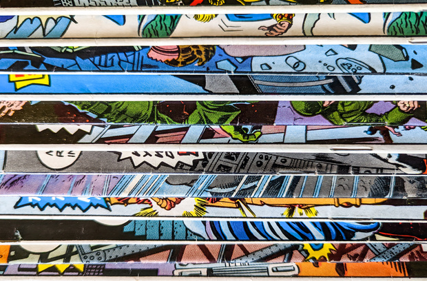 Insurance Tips for Collectors and Hobbyists A close-up of a stack of vintage comic books with colorful, illustrated covers partially visible along the edges.